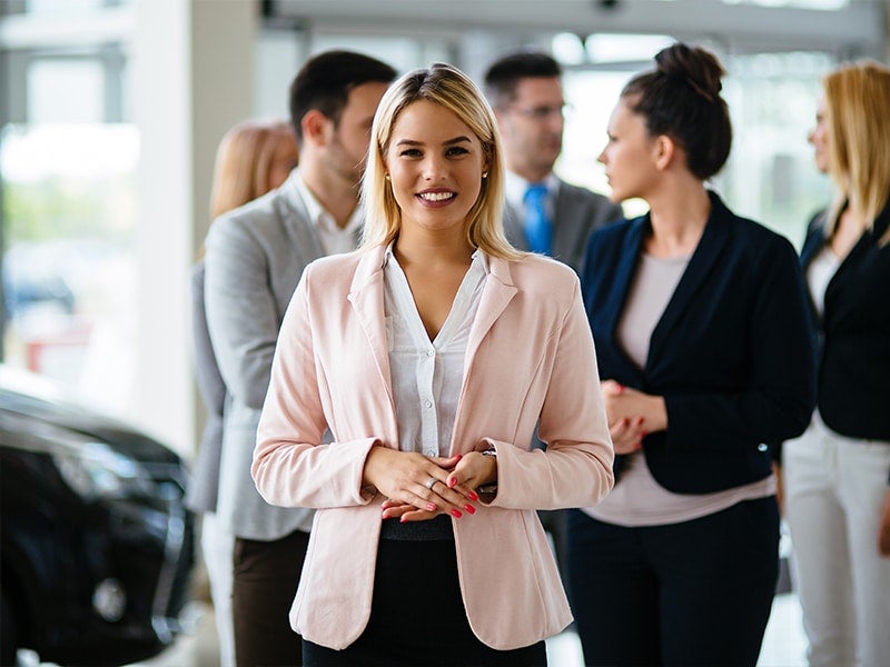 A cute women standing front of team members